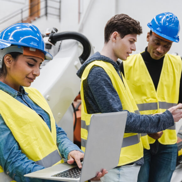 Ingénieurs industriels multiraciaux travaillant dans une usine de production automatisée et robotisée.